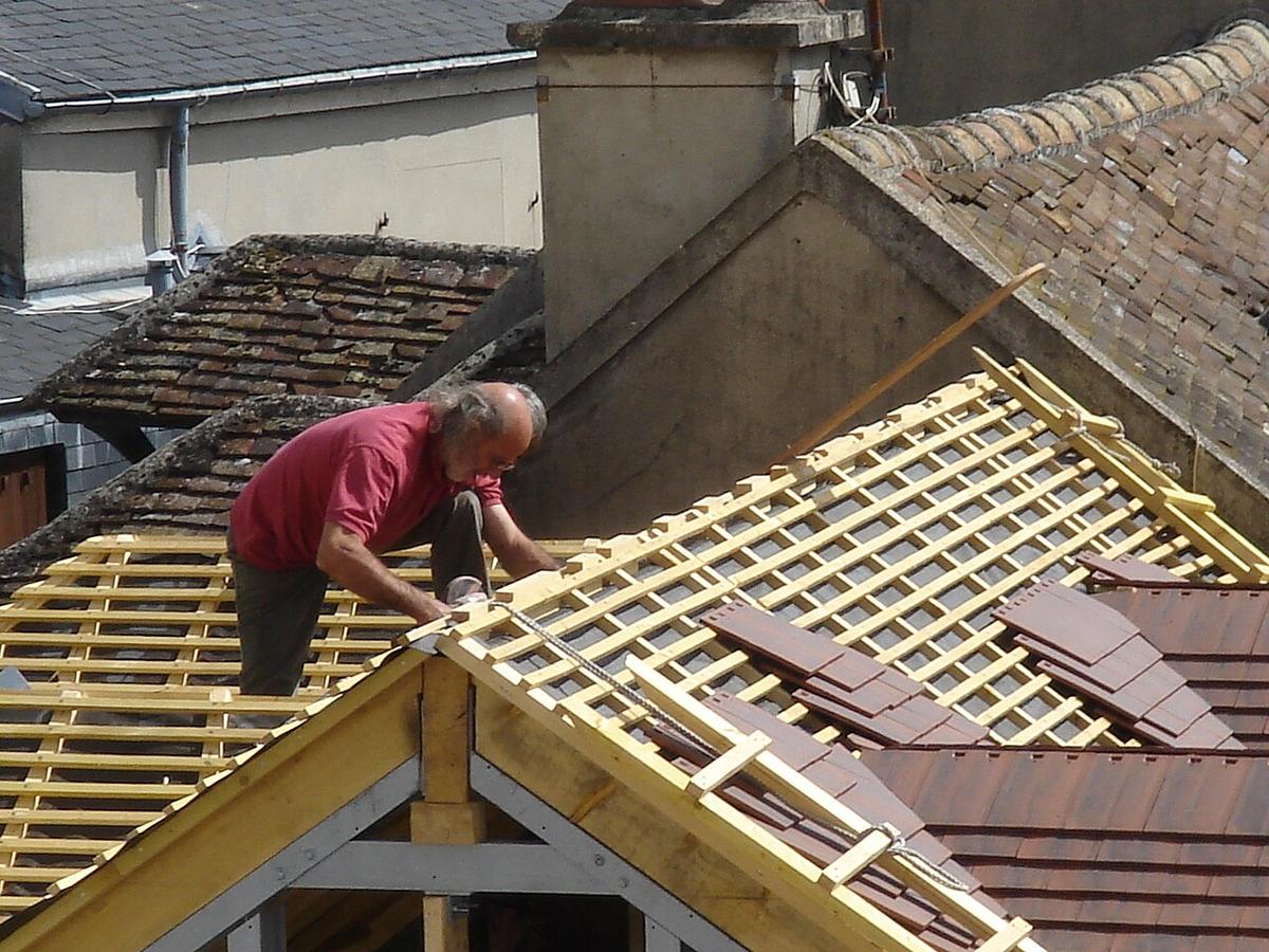 Roofer laying tiles on a roof
